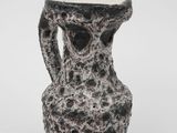 a black and white vase sitting on a white surface