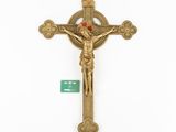 a gold crucifix with a cross on a white background