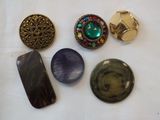 five different buttons and a cell phone on a table