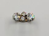 a three stone diamond ring on a white surface