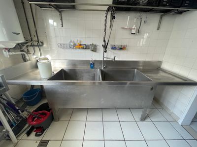un grand évier en inox au milieu d'une cuisine