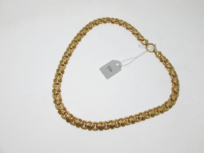 gros plan d'un bracelet en chaîne en or avec une étiquette de prix