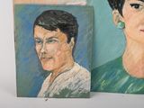 two paintings of a woman and a man are on a table