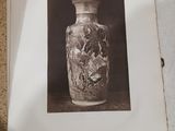 une photo d'un vase posé sur une table à côté d'un livre