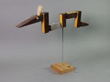 a wooden sculpture of a plane on a metal stand