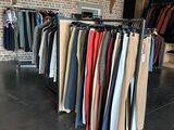 a lot of clothes hanging on a rack in a room