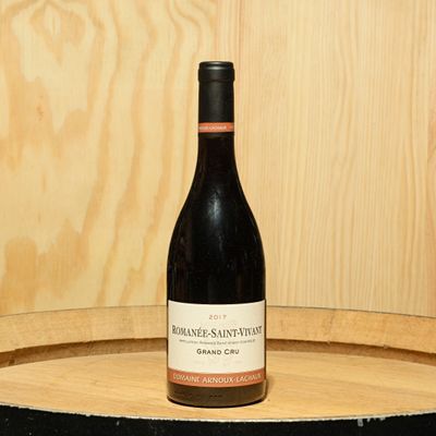 a bottle of wine sitting on top of a barrel