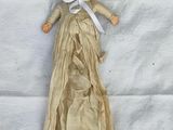 a doll that is laying down on a white sheet