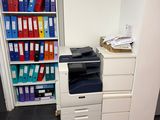 a white printer sitting on top of a white cabinet in a room