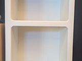 two white bookshelves in a room with a rug on the floor