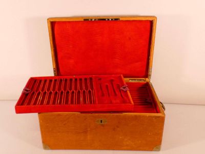 a small wooden box with a red lid on a white surface