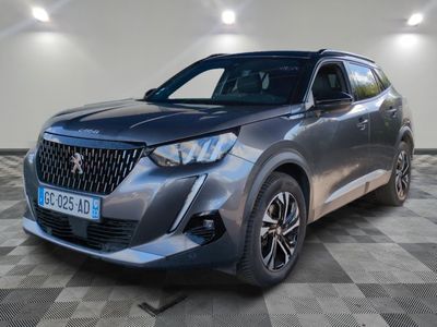 un SUV argenté garé sur un sol en damier dans un garage