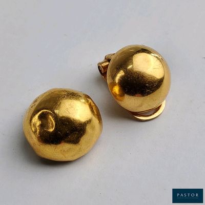 paire de boucles d'oreilles en forme de boule plaquées or sur un fond blanc