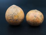 pair of two old vases with designs on them on a black surface