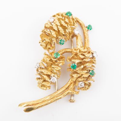 a close up of a gold brooch with green and white stones
