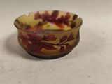 un petit bol en verre orné d'un motif rouge et jaune
