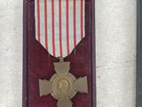 three medals and a plaque on display on a table