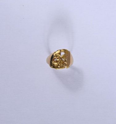 gros plan d'une bague en or sur une surface blanche