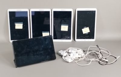 Trois iPad, une tablette et des écouteurs sont posés sur une table