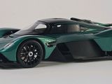a green toy car that is sitting on a white surface