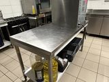 a large stainless steel table in the middle of a kitchen