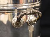 a silver pot with two handles on a black background