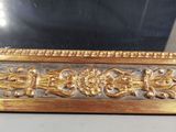 a picture of a gold frame with a mirror in the background