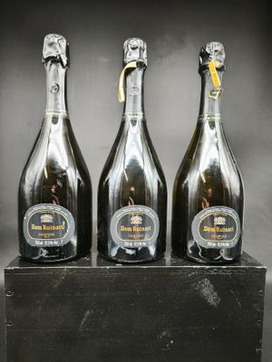 trois bouteilles de champagne posées sur un bloc de bois
