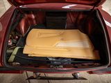 a red car with a yellow cover in the trunk of it