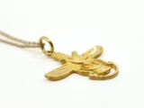 a close up of a gold dragonfly necklace on a white background
