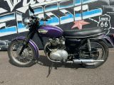 a purple motorcycle parked in front of a graffiti covered wall