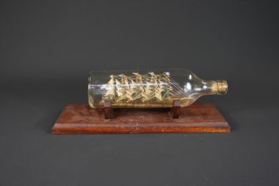 Maquette de bateau en bouteille sur socle bois.