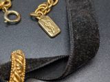 gold plated bracelet with a black velvet cord and a gold plated charm