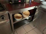 plan de travail en acier inoxydable muni de paniers, dans une cuisine professionnelle