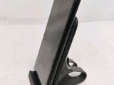a close up of a cell phone on a stand on a white surface