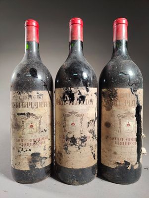 trois bouteilles de vin rouge posées côte à côte sur une table
