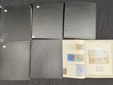 four black folders with stamps on them sitting on a table