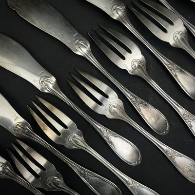 beaucoup de cuillères et de fourchettes sur une table noire