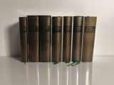 quatre livres sont alignés sur une surface blanche