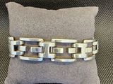 un gros plan d'un bracelet en argent posé sur un oreiller