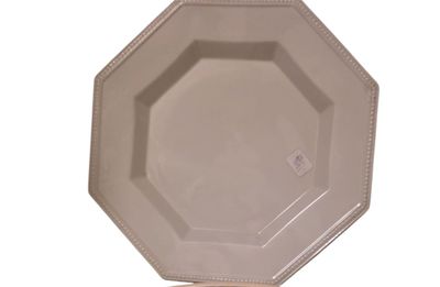 une assiette blanche posée sur un support, sur un fond blanc