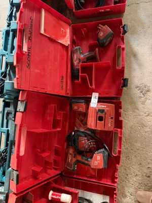 une boîte rouge posée par terre, contenant des outils