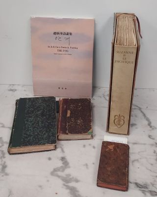 Plusieurs vieux livres sont posés les uns à côté des autres sur une surface en marbre.