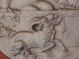 a relief of a woman sitting in a bathtub with a dog