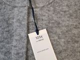 a close up of a gray sweater with a tag on it