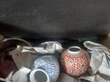 two vases sitting on top of a pile of newspaper
