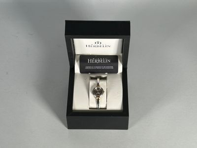 une photo d'une montre dans un coffret noir posé sur une table