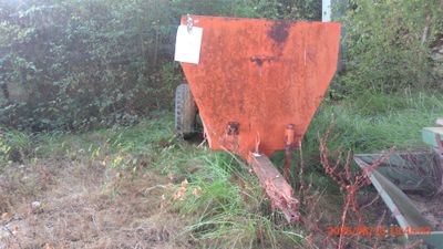 a rusted out dumpster sitting in the middle of a field