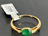 a close up of a ring with a green stone on a table