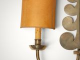 brass wall sconce with a leather shade and a brass wall sconce with a leather shade